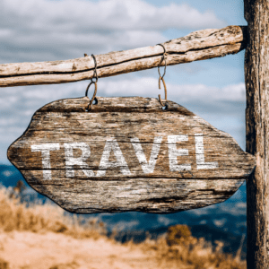 A wooden direction post with the word - travel.